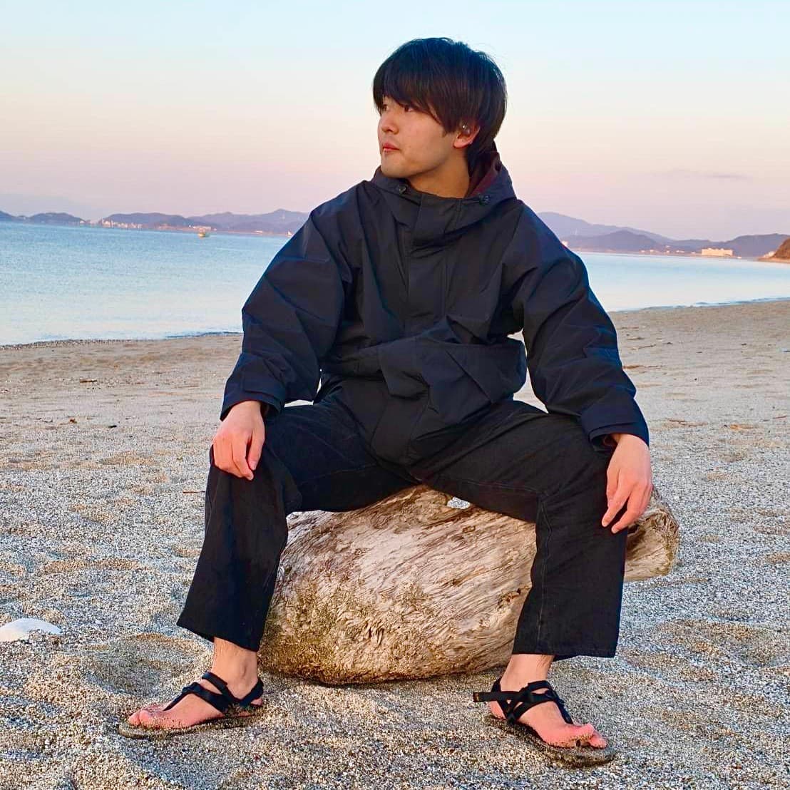 浜辺で左を向く佐々木慧